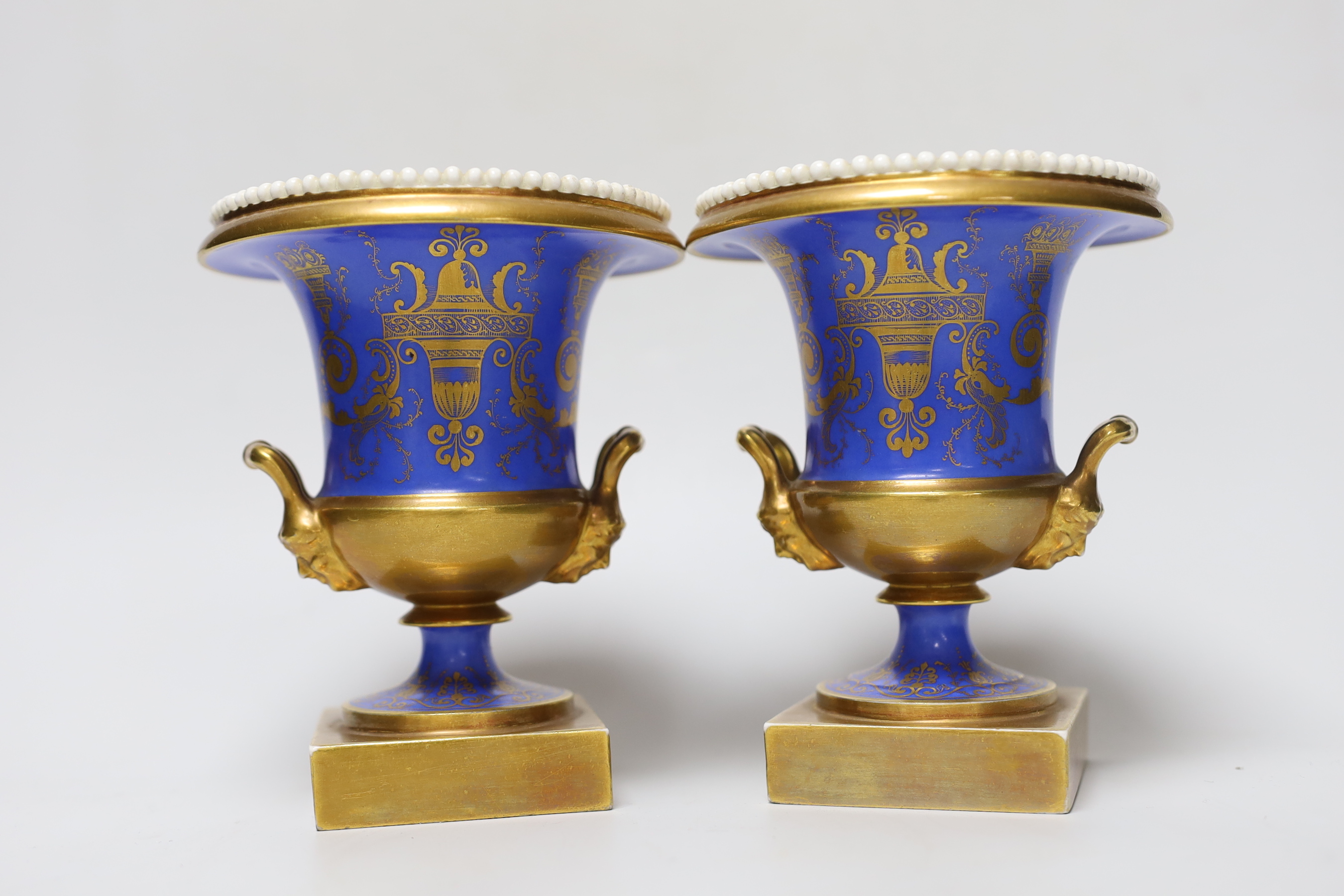 A pair of Minton twin handled urn form vases, hand painted with floral motifs, in the style of Thomas Steele, c.1820